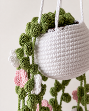 Maceta decorativa de crochet colgada en un espacio interior